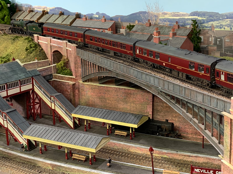 Bachmann Jubilee with express crossing bridge over low level station.